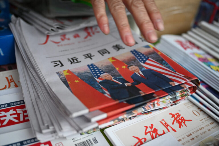 FILE - Copies of the People's Daily newspaper with a front page photo and headline which reads
