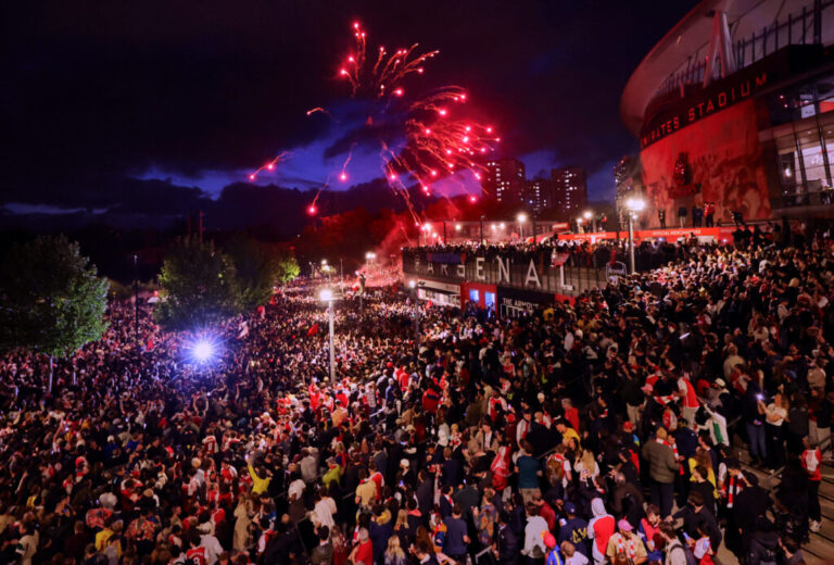 Arsenal fans celebrate winning the Premier League at Emirates Stadium on May 19 in London.