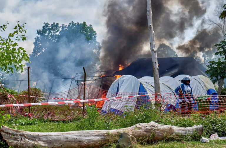 A Congolese police personnel stands guard at the burning Ebola treatment center, as aid agencies intensify efforts to contain a new Ebola outbreak involving the Bundibugyo strain outbreak, in Rwampara general hospital in Rwampara outside Bunia, Ituri province, Democratic Republic of Congo, May 21, 2026.