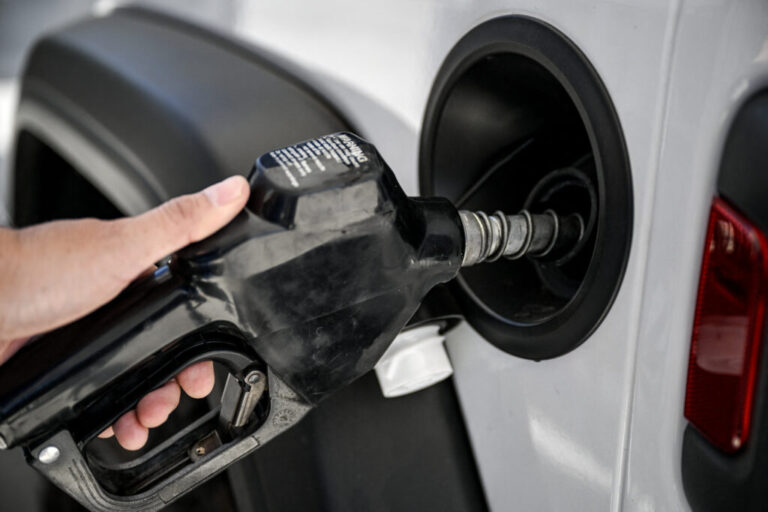 A man uses a gas pump at a Shell gas station in Houston.