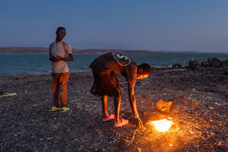 An El Molo youth stokes a fire that was lit as part of a traditional ritual hoped to bring fish and rain, on Komote Island in Lake Turkana in northern Kenya. Declining fish stocks and flooding have had a huge impact on the El Molo, one of Africa's smallest ethnic groups who now number no more than a few hundred, and whose way of life is entirely reliant on the lake.