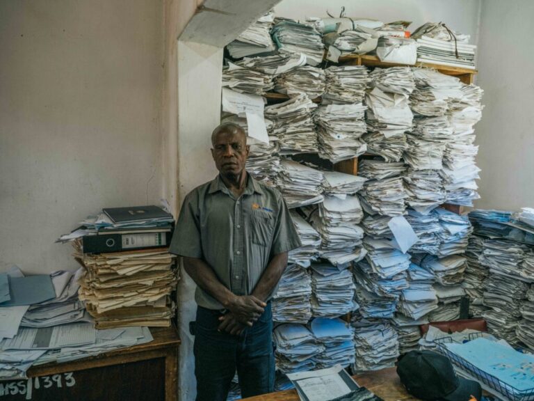 December 3, 2024. Death Registration Office, Kitwe, Zambia. Lazarus Kangasa waits at the Kitwe City Council Registration Office for a burial permit, the final step in certifying and obtaining his son’s death certificate. Photo Credit: Juan Arredondo.