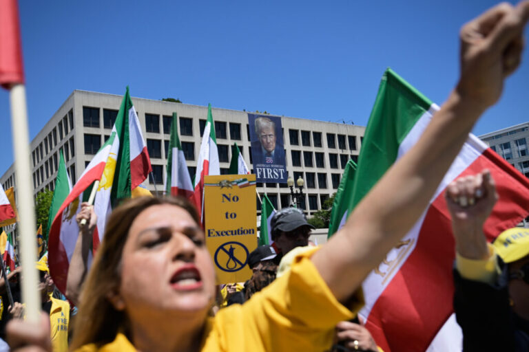 A banner of President Donald Trump hangs over Iranian Americans and their supporters as they march from the U.S. Capitol to the World War II Memorial during a rally Saturday, May 16, 2026, in Washington.