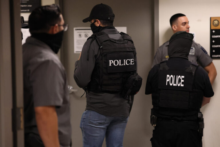 Immigration and Customs Enforcement officials stand outside immigration courtrooms while cases are being heard at 290 Broadway in New York.