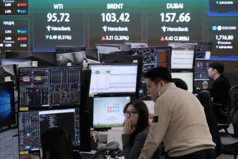 Currency traders watch monitors near a screen showing international oil prices at the foreign exchange dealing room of the Hana Bank headquarters in Seoul, South Korea, on March 18.