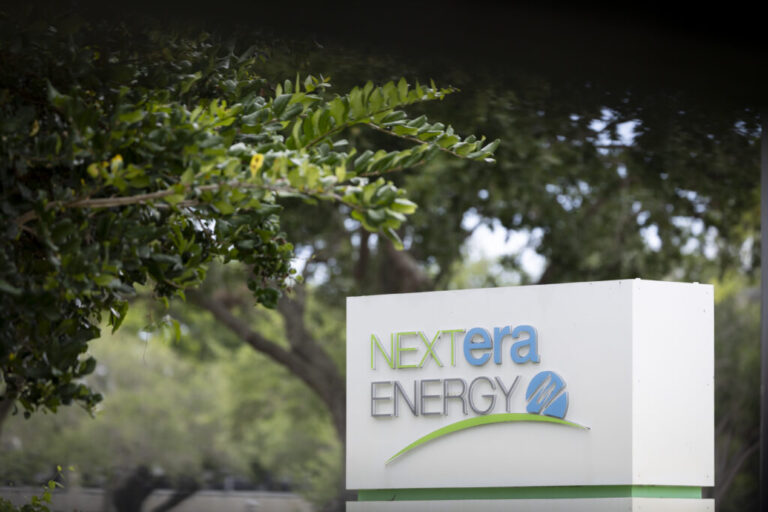 The logo of NextEra Energy is seen at the entrance of its headquarters on May 18, 2026 in Juno Beach, Florida. NextEra Energy announced plans to acquire Dominion Energy on Monday in an all-stock transaction valued at roughly $67 billion, merging two large utilities as electricity demand rises with AI and data center expansion.