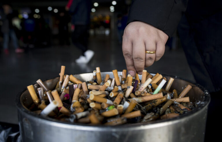 In this photo taken on February 28, 2017, a man grinds out his cigarette in an ashtray at a railway station in Shanghai. Shanghai widened its ban on public smoking March 1 as China's biggest city steps up efforts to stub out the massive health threat despite conflicts of interest with the state-owned tobacco industry.