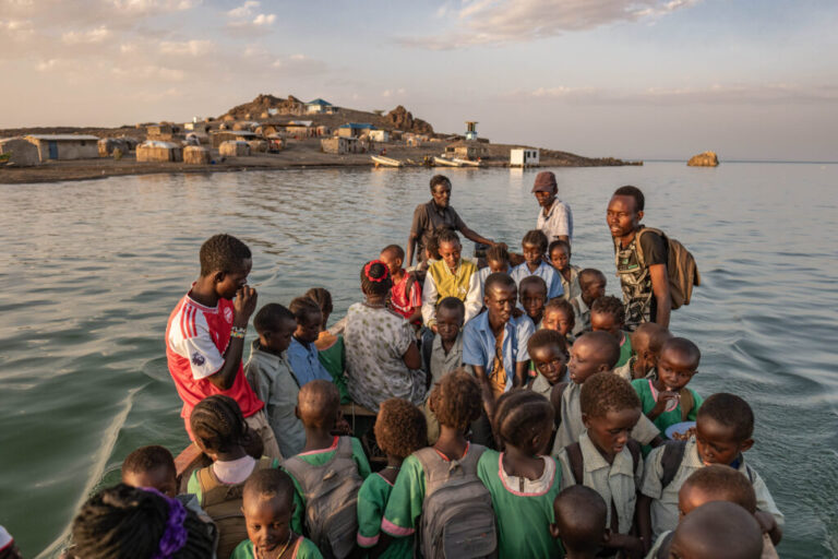 El Molo children travel to school by boat from their home on Komote Island, a new island formed by rising water levels in lake Turkana. The boat rides cost families 100 shillings per child per crossing, a huge daily expense for families already living below the poverty line. When the weather is stormy, children are forced ton stay home and miss school. In addition to the flooding, declining fish stocks have further exacerbated the community's financial struggles.