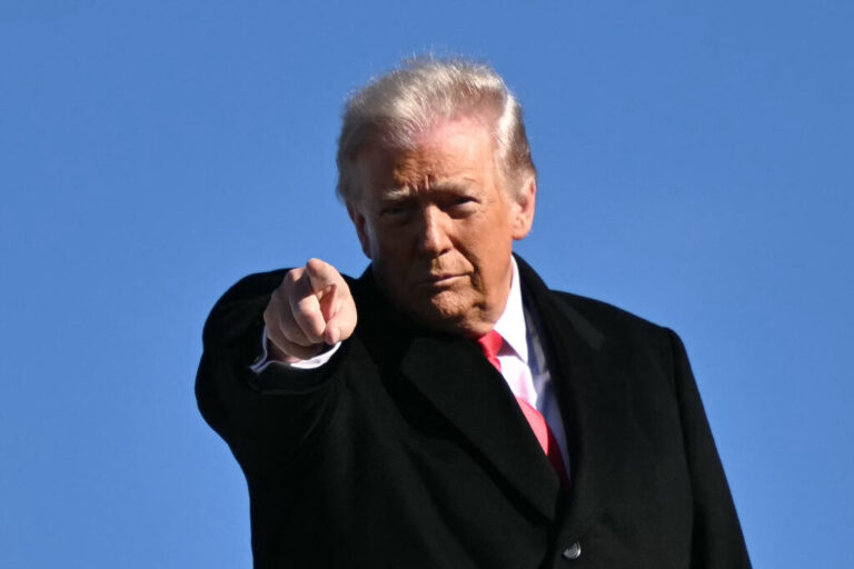 President Trump points at something in front of him as he boards Air Force One.