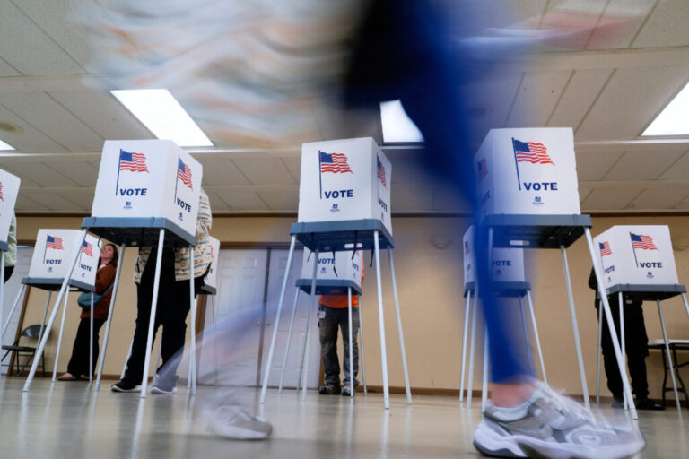 Voters cast their ballots in Oak Creek, Wis., in 2024. The voting booths have American flags printed on them and the word