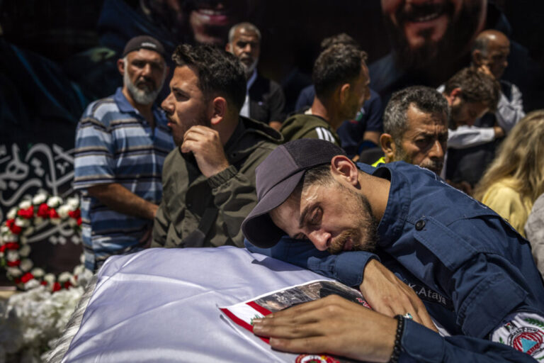 Hundreds of mourners marched on Thursday behind the coffins of three Lebanese Civil Defense paramedics killed by Israeli strikes in southern Lebanon. Their fellow paramedics, dressed in uniform, carried the coffins draped with Lebanese flags on their shoulders and saluted them, while mourners wept.