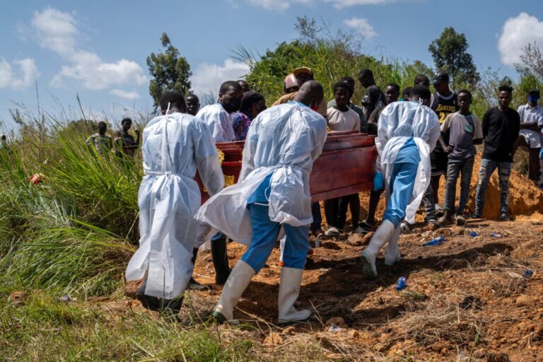 Health workers carry the coffin of a person suspected of having died from Ebola in the Democratic Republic on Congo.