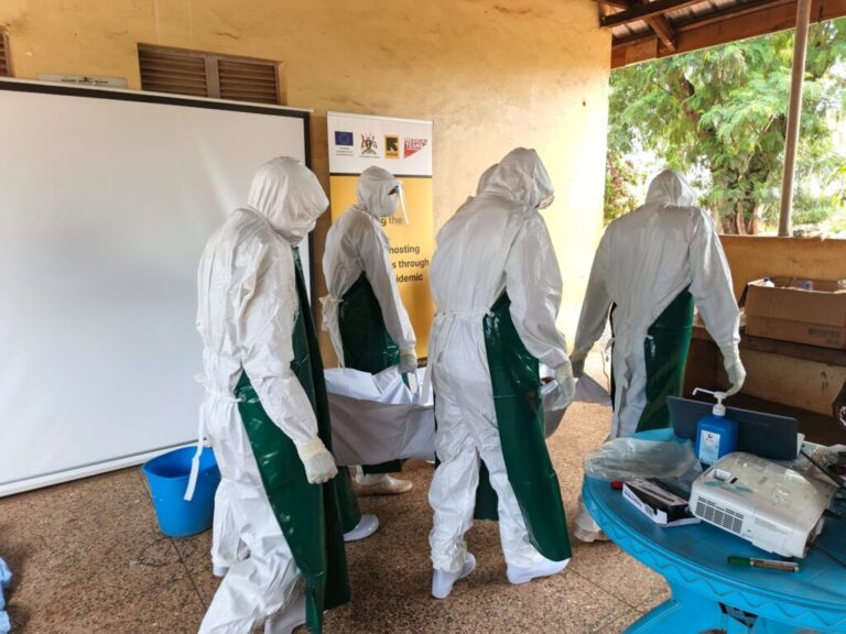 Healthcare workers participate in a simulation exercise in Uganda, practicing how to conduct a safe and dignified burial for a deceased Ebola patient.