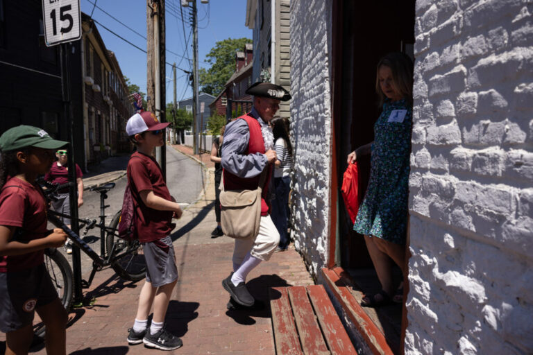 A reenactor enters Waterfront Warehouse with a group of schoolchildren in Annapolis, Md., June 4, 2026.