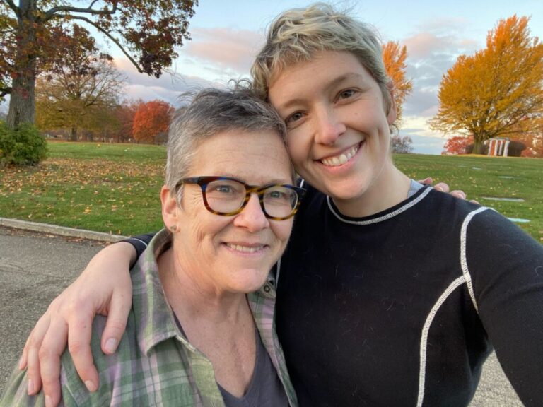 In this photo, Missy Nicholson stands next to her daughter, Sonny Nicholson. They each have an arm wrapped around the other's shoulders.