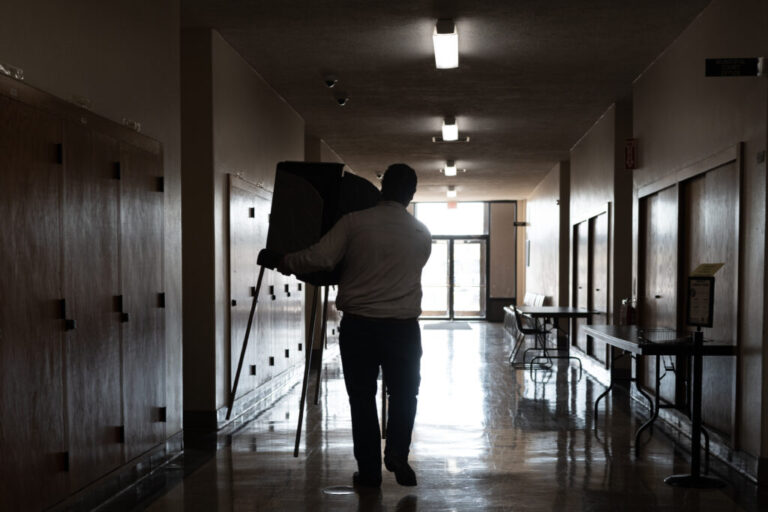 A staffer with the Kenosha County clerk's office sets up voting booths on Oct. 21, 2024, in preparation for in-person early voting in Kenosha, Wis.
