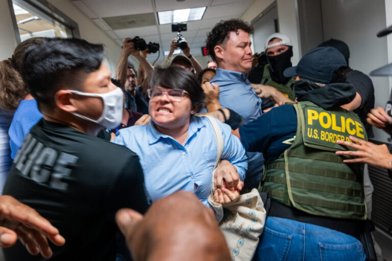 A Paraguayan woman whose relative was detained by federal agents scuffles with officers in the halls of immigration court at the Jacob K. Javits Federal Building in New York City in July.