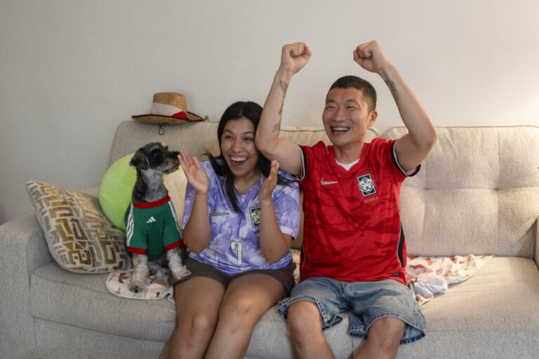 Mirella Vargas and her husband, Bonyub Koo, watch a soccer match with their dog in Los Angeles on June 11.
