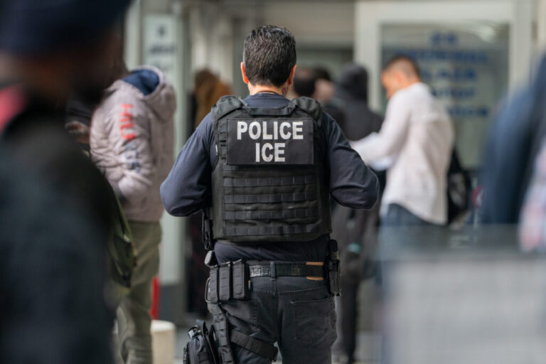 An ICE officer monitors hundreds of asylum seekers being processed upon entering the Jacob K. Javits Federal Building on June 6, 2023 in New York City.