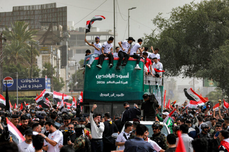 Members of Iraq's men's national football team sit atop a double-decker bus as they are paraded with fans in the Jadriya area of central Baghdad on April 4, 2026 to celebrate the country's qualification to the 2026 FIFA World Cup to be held in North America in the summer.