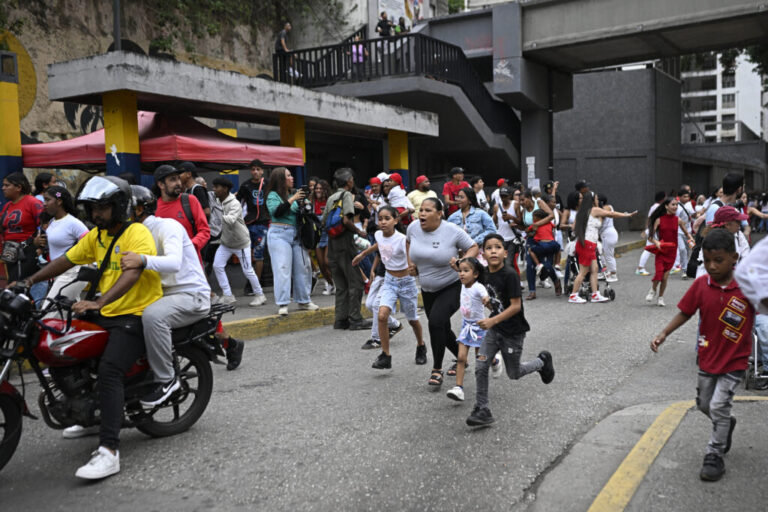 People run into a street following an earthquake in Caracas.