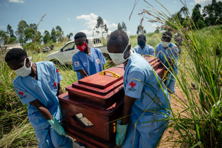 Members of a Congolese Red Cross team carry the coffin of a woman suspected of having died from Ebola virus disease during her safe burial at a cemetery in Bunia on June 7, 2026.