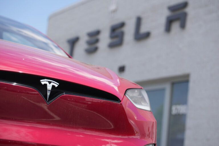 A 2023 Model X sports-utility vehicle sits outside a Tesla dealership Sunday, June 18, 2023, in Littleton, Colo. After enjoying a strong run where they could keep raising prices to boost their profits, companies are now stuck in a vise. On one end, revenue is under pressure as the global economy remains fragile. On the other, companies are having to pay higher wages for workers, among other costs. Caught in the middle are corporate profit margins, which measure how much profit companies make on each $1 of revenue. (AP Photo/David Zalubowski, File)