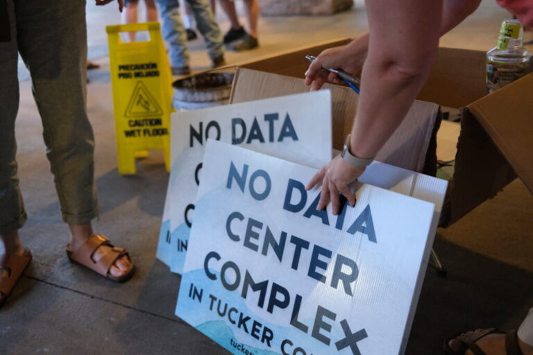 Volunteers hand out yard signs in June against a data center complex in West Virginia.