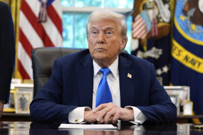 President Donald Trump listens to a reporter's question in the Oval Office of the White House, on Friday.