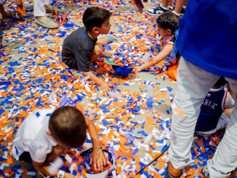 New York Knick fans celebrate winning the 2026 NBA Championship with a ticker tape parade at City Hall.