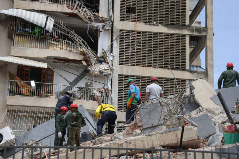 People and rescuers work on the debris of a collapsed building in Caracas after a pair of strong earthquakes struck Venezuela.