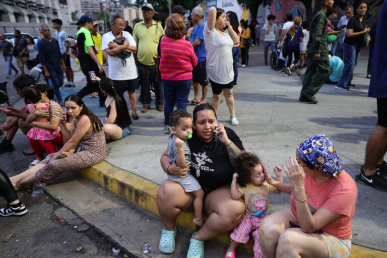 Evacuated people speak by phone waiting at Parque Central urban development complex.
