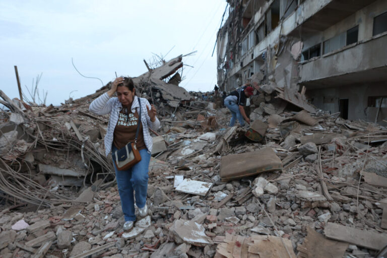 Residents walk among the rubble of building damaged in earthquakes the previous day in Catia La Mar, Venezuela.