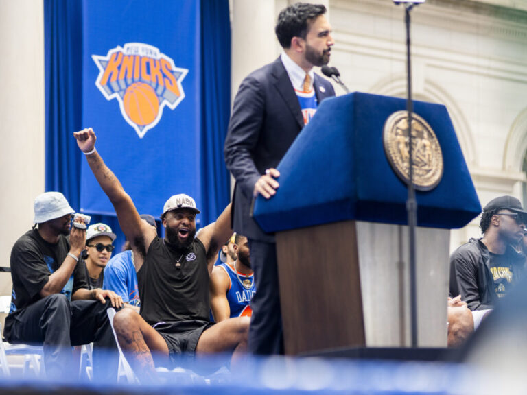 New York City Mayor Zohran Mamdani gives a speech introducing the New York Knicks as they celebrate winning the 2026 NBA Championship at City Hall. Elias Wlliams for NPR