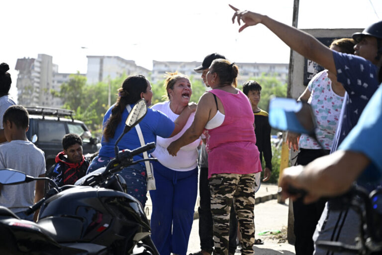 People react near a damaged apartment building following an earthquake in Catia La Mar, La Guaira state, about 30 km northwest of Caracas.