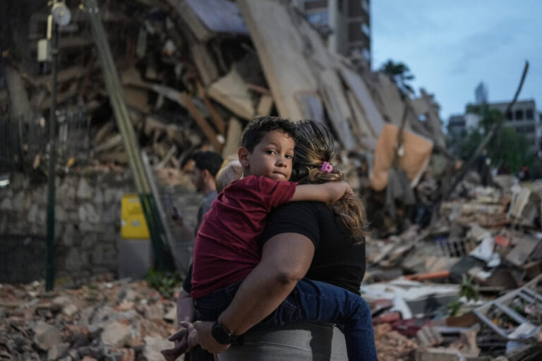 People walk past a collapsed building following an earthquake in Caracas on June 25, 2026.