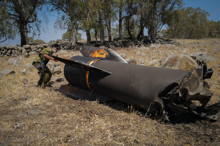 Members of the Israeli security forces check the apparent remains of an Iranian ballistic missile lying on the ground on the outskirts of Qatzrin, Golan Heights, Israel.