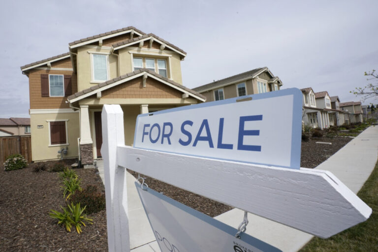 A for sale sign is posted in front of a home in Sacramento, Calif.