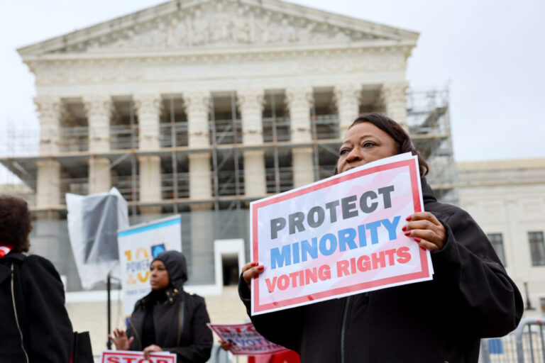 A demonstrator holds a sign saying “PROTECT MINORITY VOTING RIGHTS” at a March 2025 rally outside the U.S. Supreme Court in Washington, D.C.