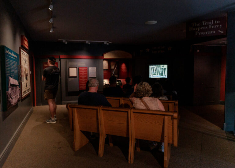 Visitors to the John Brown Museum watch an informational video at Harpers Ferry National Historical Park on June 18, 2026.