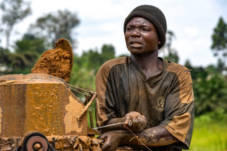 Léon Gina operates a piece of mechanical equipment at the Maidede mine in Mongbwalu, Ituri province, Democratic Republic of Congo, on June 16, 2026. Photographed from about the waist up, Gina is wearing a black short-sleeved shirt and a black knitted cap.
