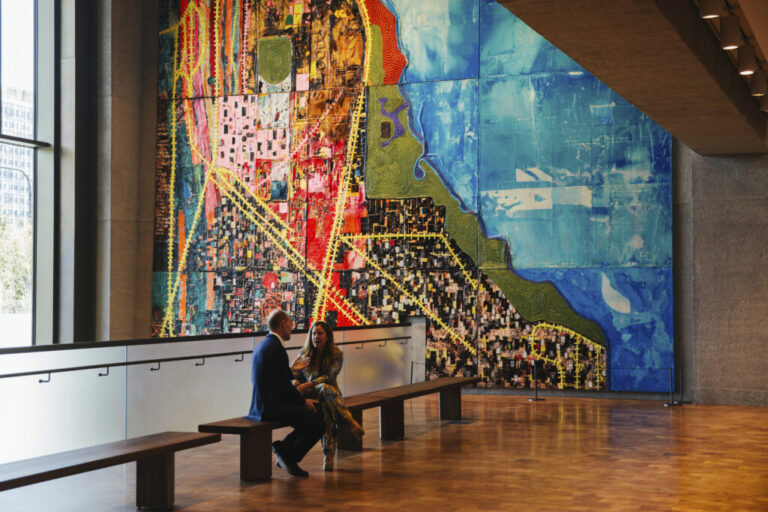 Visitors sit in front of Mark Bradford’s
