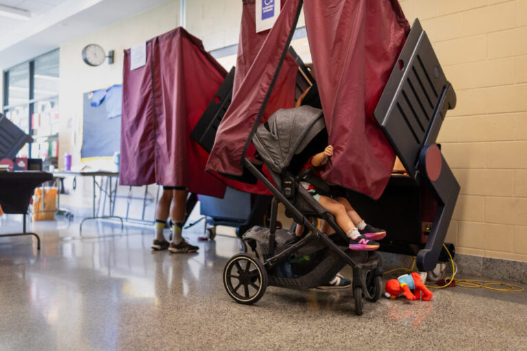 A young child waits for her mom to finish voting at Phillis Wheatley Community School in New Orleans on May 15. Many voting machines in Louisiana are decades old.