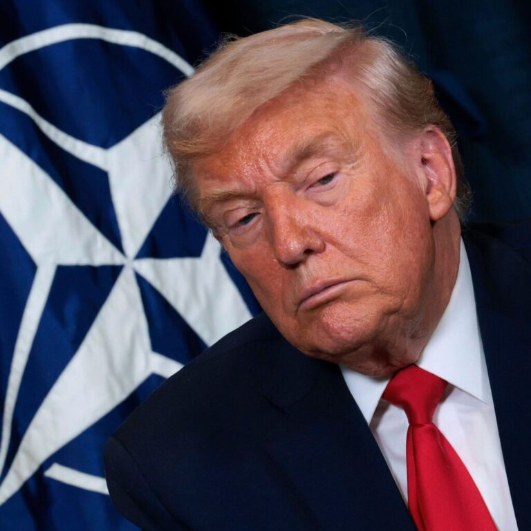President Donald Trump in front of NATO flag.