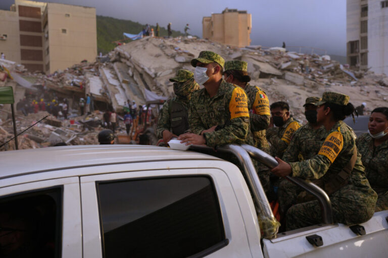 Venezuelan firefighters and volunteers search for possible victims atop a collapsed building in Caraballeda, La Guaira state, Venezuela, on June 27.