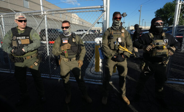 Immigration and Customs Enforcement agents stand near a gate at Delaney Hall, an immigrant detention center in Newark, N.J., in May 2025.