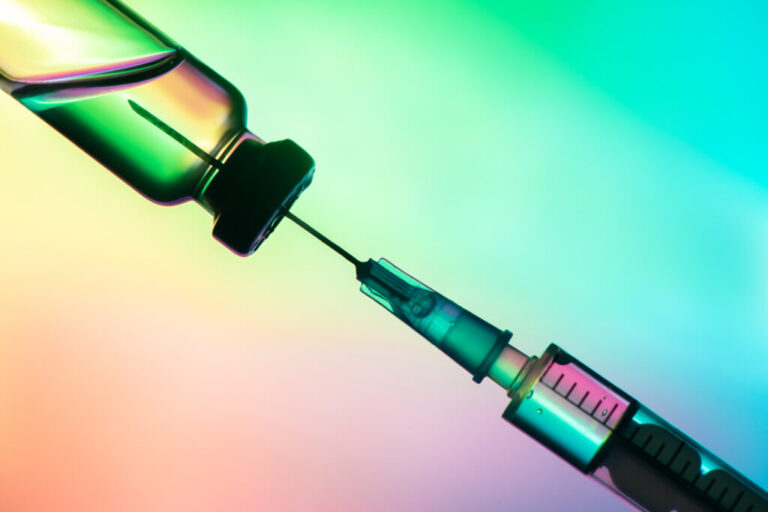 vaccination syringe and bottle on a colored background. close up, copy space