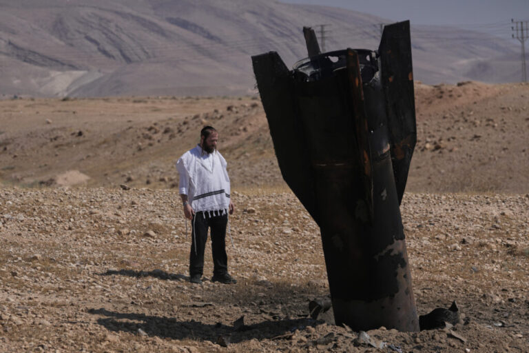 A man looks at the wreckage of an Iranian missile that landed near the West Bank city of Jericho on Monday.
