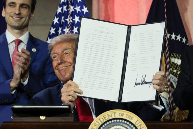 President Trump displays a signed executive order after delivering remarks on his AI plan at the Andrew W. Mellon Auditorium on July 23, 2025 in Washington, DC. /Getty Images)
