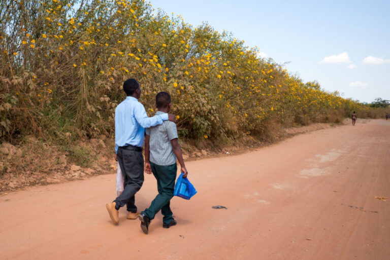Gift and Alumbwe walk to school. Gift hopes to become an engineer; Alumbwe wants to be a soldier.